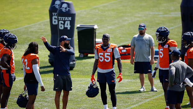 Denver Broncos outside linebackers coach Michael Wilhoite talks with linebacker Nik Bonitto (42) and linebacker Frank Clark (55) and linebacker Randy Gregory (5) during training camp at Centura Health Training Center.
